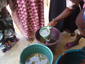 Formation en savonnerie à la Maison de la Femme : Etape du dosage des ingrédients (soude, beurre de karité, huile de coco, silicate de sodium et parfum)